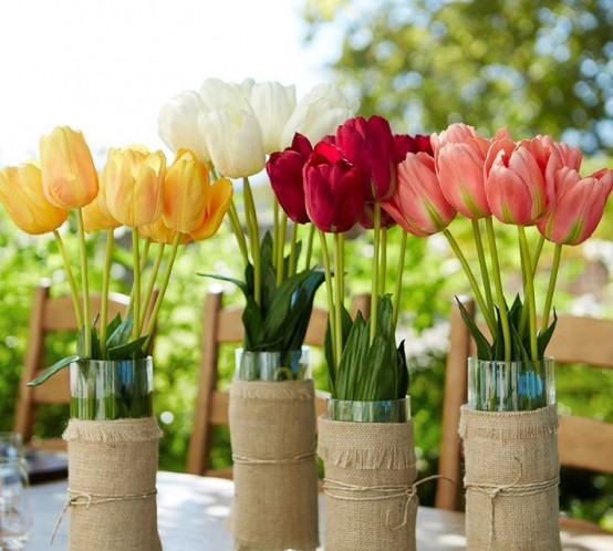 clear glass vases wrapped with burlap and with bright spring tulips are nice decorations, centerpieces for spring