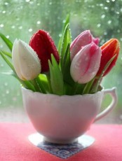 a vintage teacup with various bright tulips is a cool sprign or Easter decoration for your kitchen or any other space