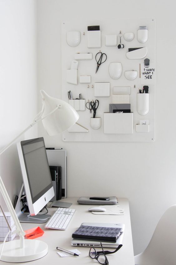 a creative white wall mounted organizer with various vases, holders and holding units for all the office stuff