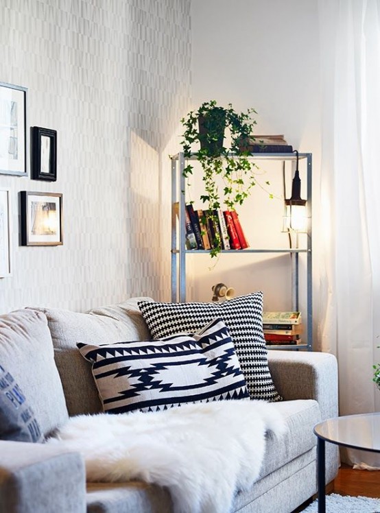 an IKEA Hyllis shelving unit with books, greenery and hanging lights is a very comfrotable storage unit