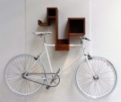 a creative mid-century modern wall-mounted shelf that holds a bike is a lovely way to store it and display at the same time