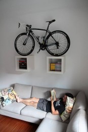 two box shelves attached to the wall and holding a bike can be a nice solution for a contemporary space and you may attached them anywhere, not only in an entryway
