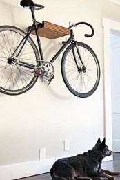 a small floating wooden shelf attached high to the wall will let you store the bike without sacrificing any floor space