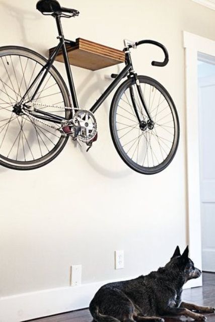 a small floating wooden shelf attached high to the wall will let you store the bike without sacrificing any floor space