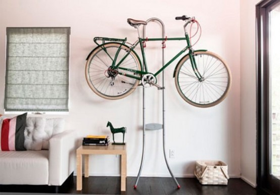 a metal stand with hooks to hold a bike is a cool and lovely idea for any space, it's very stable and you can DIY it easily