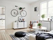 a colorful plastic holder for storing your bike by the wall is a lovely idea to add a cool touch to the space and to save some space at the same time