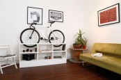 a white storage unit can also hold your bike if you make proper cuts in it, and it will become part of decor