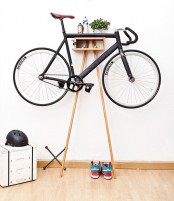 a small and ergonomic storage unit is a cool stand for a bike and can be placed anywhere, from an entryway to a porch, and it features some storage space, too