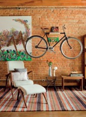 attach a holder to the wall to store your bike while making it part of decor and adding interest to the space
