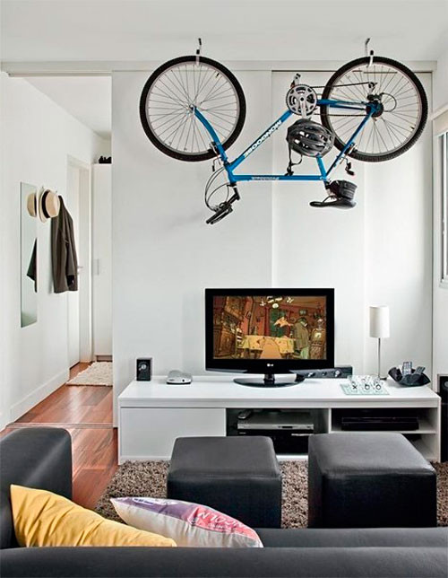 two hooks attached to the ceiling can easily hold a bike making it a very creative and dynamic decor element in the space