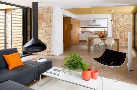 a modern living room with a black Malm fireplace suspended, a graphite grey sofa, a black chair and a white coffee table plus potted greenery