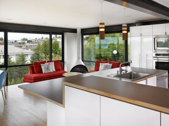 a modern living room with glazed walls, red sofas, a white Malm fireplace in the corner for maximal coziness and an inviting feel in the room