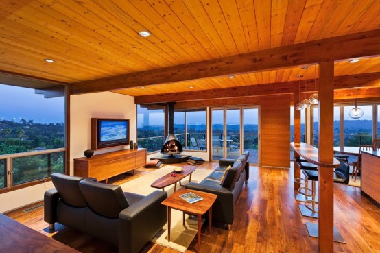 a modern ranch-style living room with lots of stained wood and black seating furniture, a black Malm fireplace that perfectly fits the interior of the room