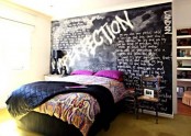 a unique modern bedroom with a black graffiti wall, a bed with bold and black bedding and a closet hidden behind this wall is wow