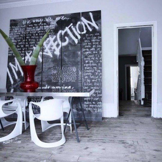 a modern black and white dining room with modern black and white dining furniture and a super bold graffiti accent wall is wow