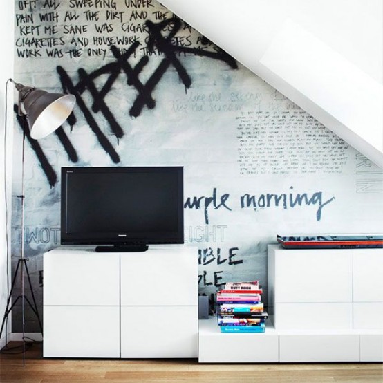 a Scandinavian living room with laconic white furniture, a TV, a floor lamp and a bold graffiti on the wall is wow