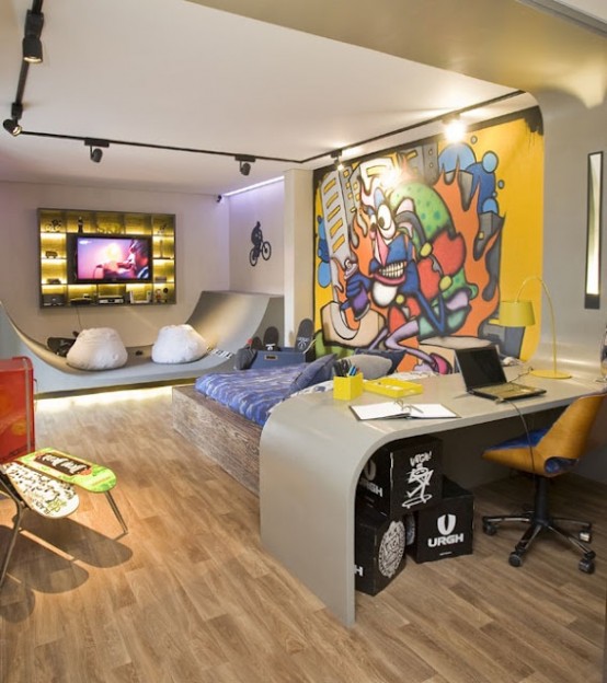 a bold and catchy teen bedroom with an accent wall done with graffiti, a curved desk and a yellow chair, a platform bed and a gaming space