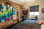 a kid’s room with comfortable dark furniture and a super bold graffiti accent wall that brings color and interest to the space