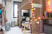 a shared farmhouse bedroom with a stained shared bed, a colorful string light garland and some pretty details that make this space very cozy