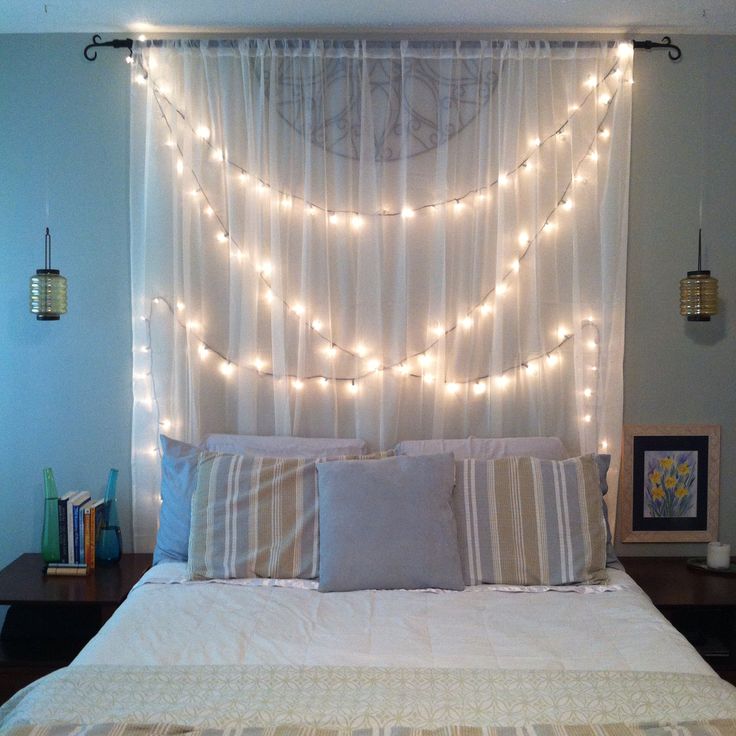 a welcoming bedroom with a headboard of a semi sheer curtain and string lights integrated to accent the space and make it more lit up
