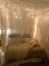 a neutral bedroom with a low bed with taupe bedding and a dreamy semi sheer canopy with string lights is a lovely idea for a neutral space