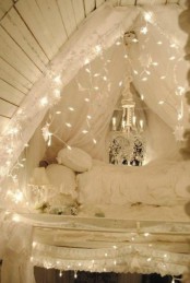 an attic bedroom with a bed and refined white bedding, with strign lights all over the sleeping space to make it dreamy