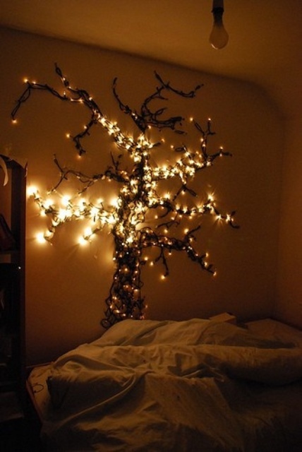 a neutral bedroom with a strign light masterpiece - a whole tree installation on the wall that looks spectacular and wows