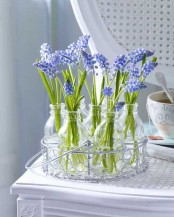a wire basket with bottles and blue hyacinths is a lovely and fresh spring decor idea with a rustic feel