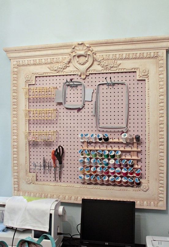 a blush pegboard in a vintage frame with wire baskets, frames and ledges