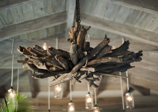 a driftwood chandelier with bulbs is a chic idea for a coastal home
