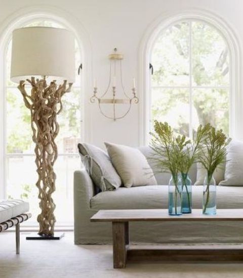 an oversized driftwood floor lamp with a neutral lampshade if s stylish idea for a coastal home
