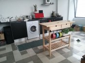 a simple wooden Forhoja cart with a metal trail for holding a planter with herbs is a nice and space-saving kitchen island