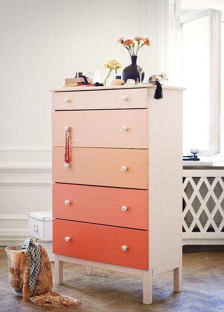 an ombre coral Tarva hack with each drawer of a different shade and white knobs for a touch of color