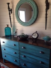 a turquoise Tarva dresser with a dark stained countertop and vintage handles for a coastal home