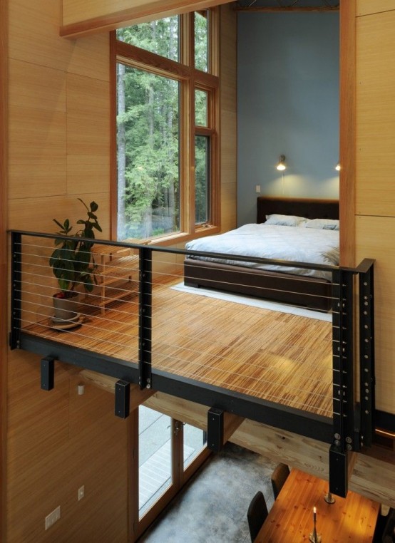 a Japandi loft bedroom with a large window, a bamboo floor, a dark-stained bed with neutral bedding and some lights over the bed is cool and relaxing