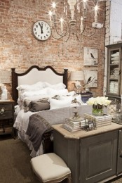 an elegant vintage bedroom is made more modern and edgy with an exposed brick wall, which reduces the level of polish