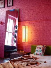 a colorful modern bedroom makes a statement with a red brick wall that takes over the whole space