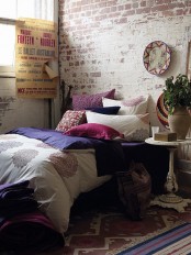 a colorful boho bedroom is made more modern and edgy with a whitewashed brick wlal