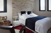 a small and chic bedroom with a fake brick wall done with panels that adds texture and a chic modern touch