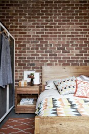 an exposed brick wall, light stained wooden furniture, a chalkboard closet create a space with much texture