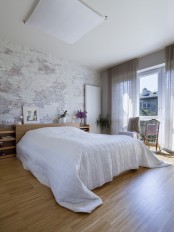 a contemporary bedroom with a whitewashed and shabby brick wall that adds a raw feel to the space