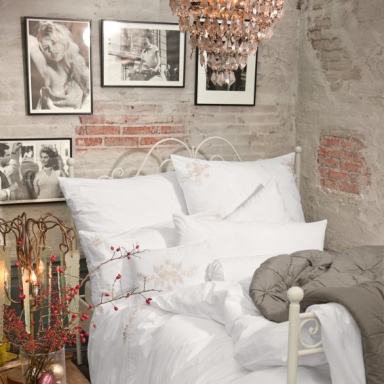 partly painted and partly no brick wall, a forged bed and a crystal chandelier create a gorgeous space