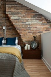 a moody bedroom with a dark brick wall going with a sculptural line, vintage furniture and accessories show off the style of the owner