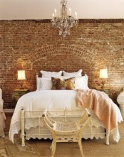 a girlish vintage bedroom with a sandy brick wall, a metal bed and shabby chic and vintage items