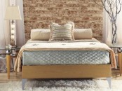 a contemporary bedroom in beige and grey with a faux brick wall for a stylish accent at the headboard