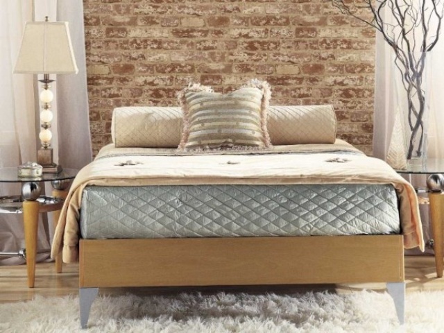 a contemporary bedroom in beige and grey with a faux brick wall for a stylish accent at the headboard