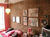 a brigth and fun bedroom with an exposed brick wall, a gallery wall and colorful touches here and there