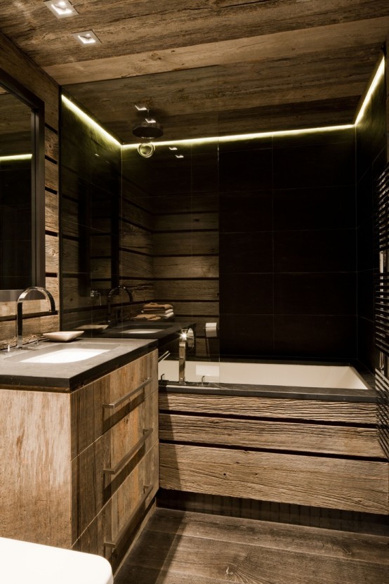 a contemporary chalet bathroom with light-stained wood all over, with black tiles, built-in lights and a floating vanity