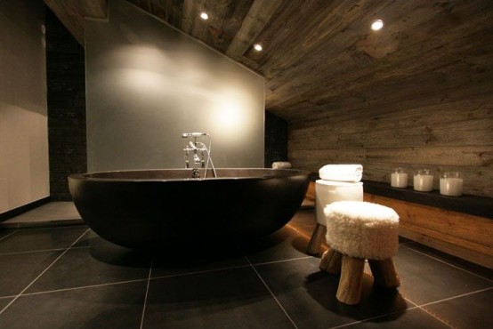 a refined contemporary bathroom clad with large scale tiles, with a frosted glass shower space and reclaimed wood on the ceiling