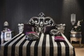 a catchy modern Gothic bedroom with a black textural wall, a refined metallic bed, shiny nightstands and bold bedding, striped and purple
